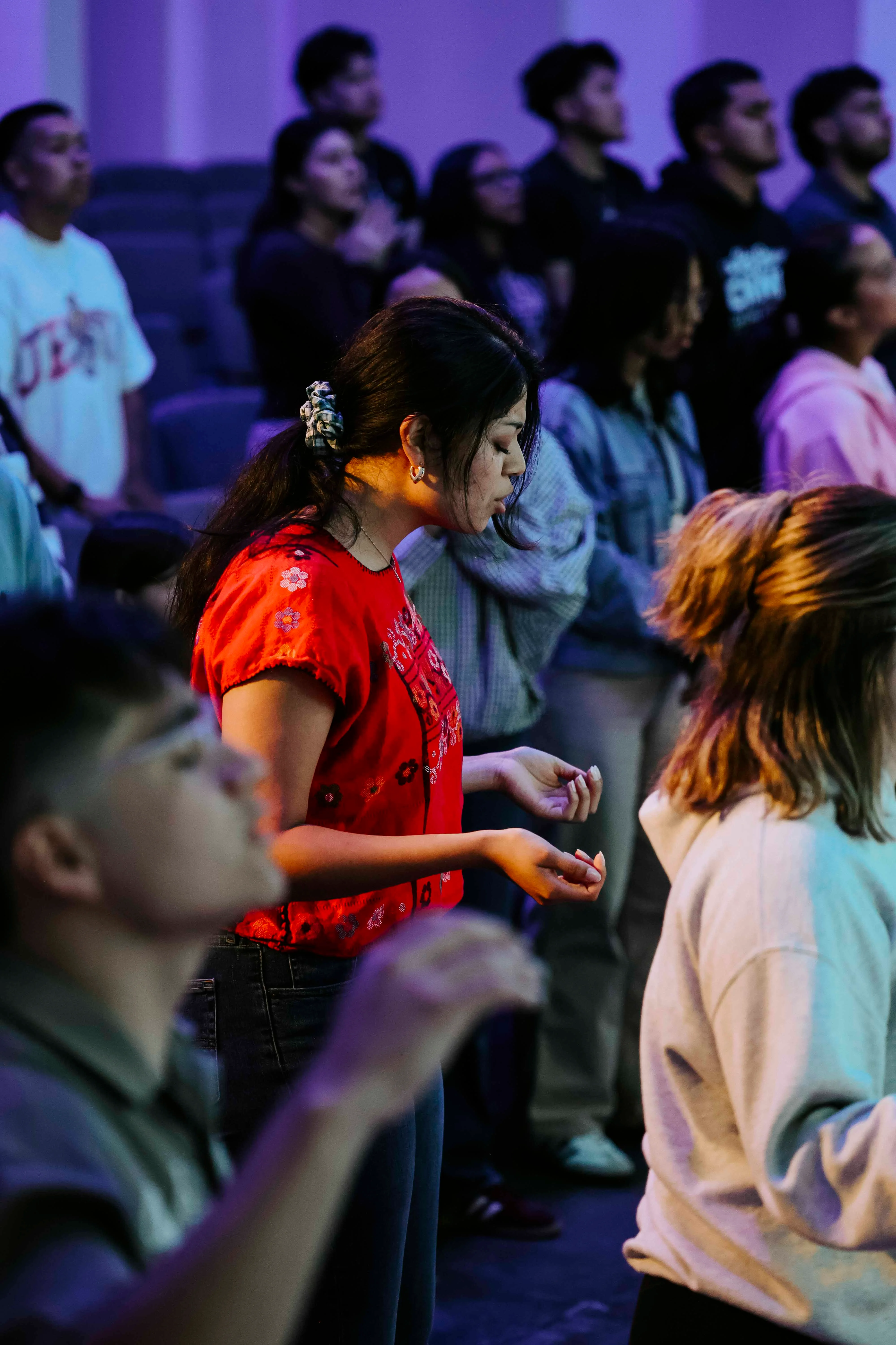Young adults praying together at NightLife