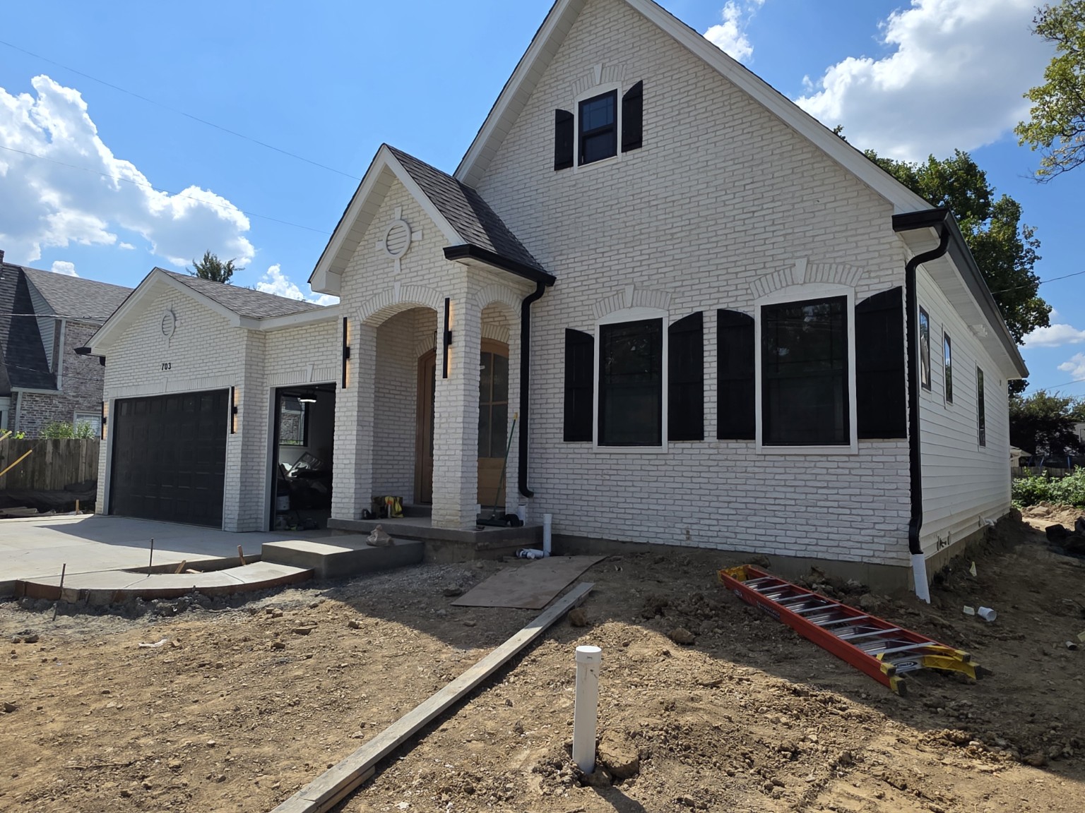 Finished black K-style gutters on a white brick new-construction home in Kirkwood Missouri