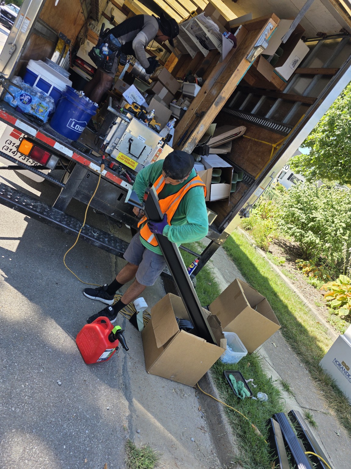 SuperRoofer crew preparing black gutter materials on site