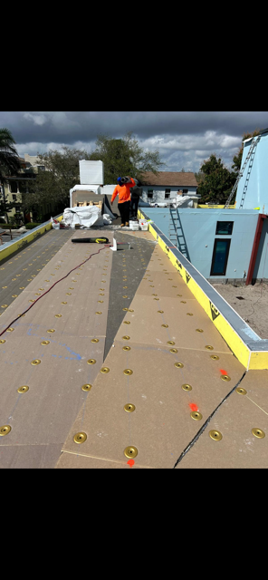 AGK crew installing tapered ISO insulation boards — flat roof South Florida