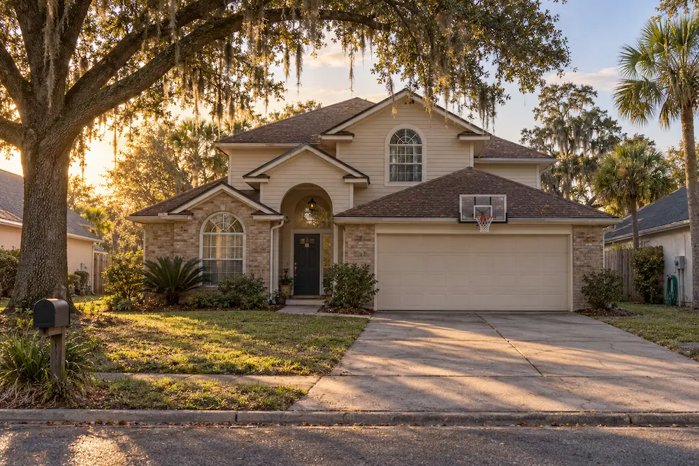 Typical two-story 1990s suburban home under live oaks in Fruit Cove, St. Johns County, FL