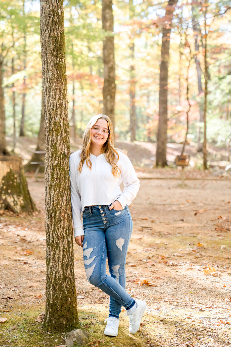 A groom in a blue suit wipes away tears while standing in a kitchen with his bride.
