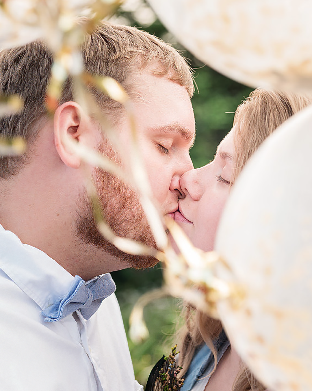 A couple kissing in the middle of baloons.