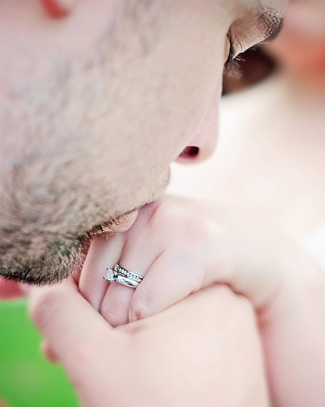 A man kisses his fiance's hand during an engagement photo session in Johnson City.