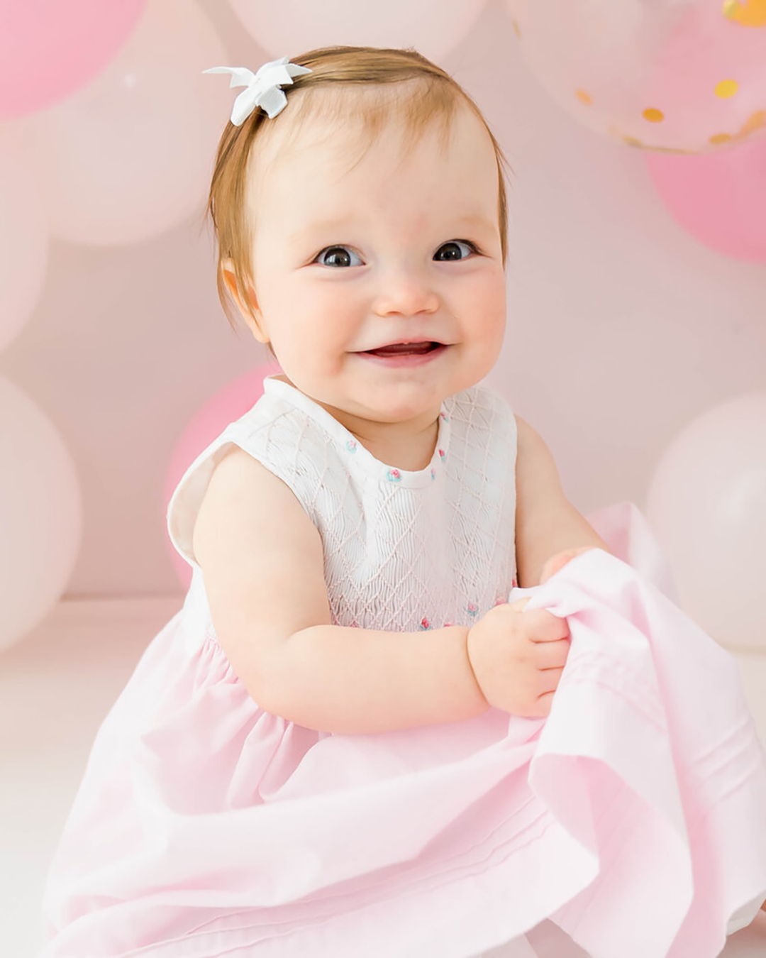 A baby girl dressed in pink during a Johnson Ciity milestone session.
