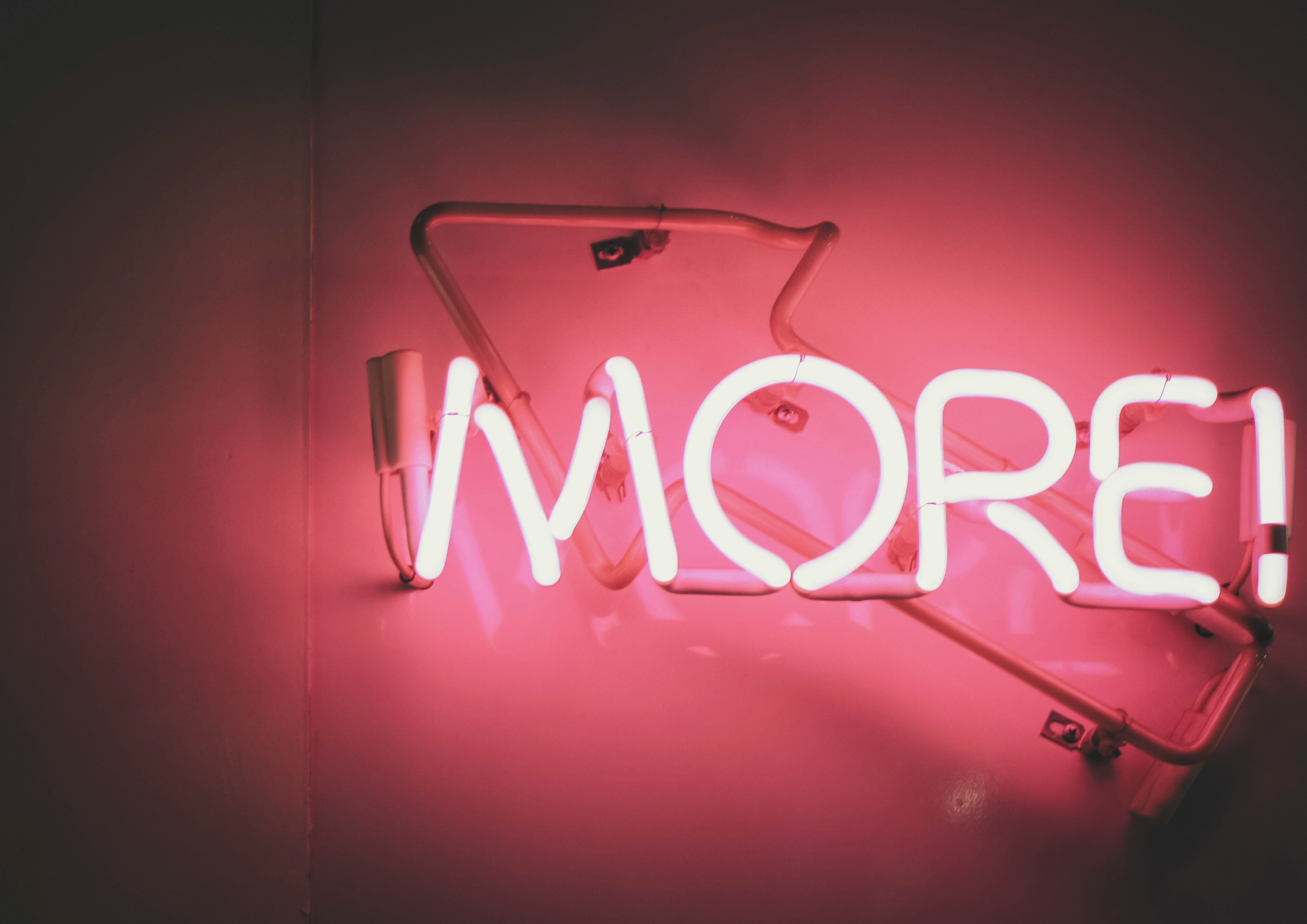 Red neon sign saying 'more'