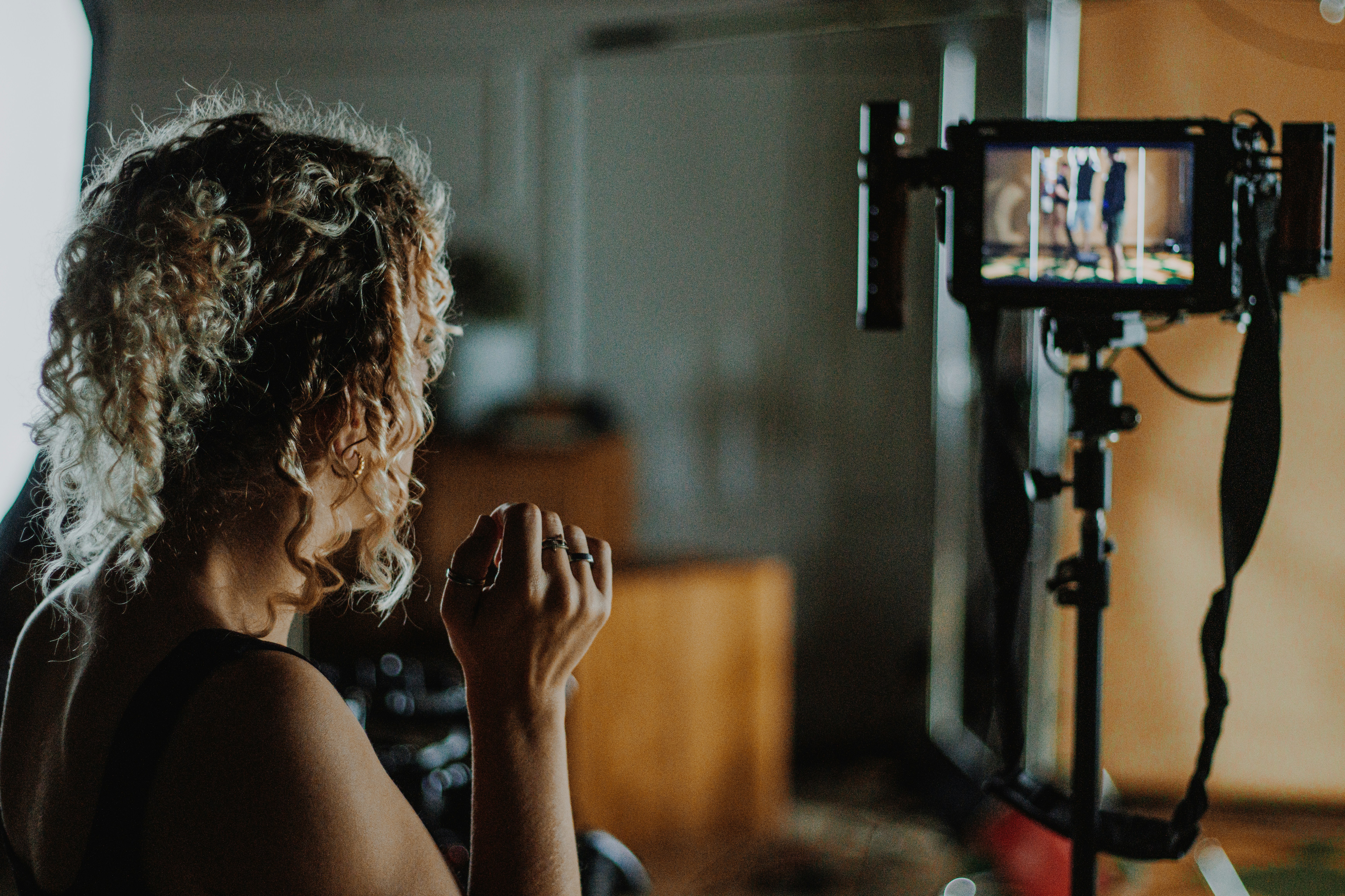 woman behind the scenes watching something being filmed on camera 