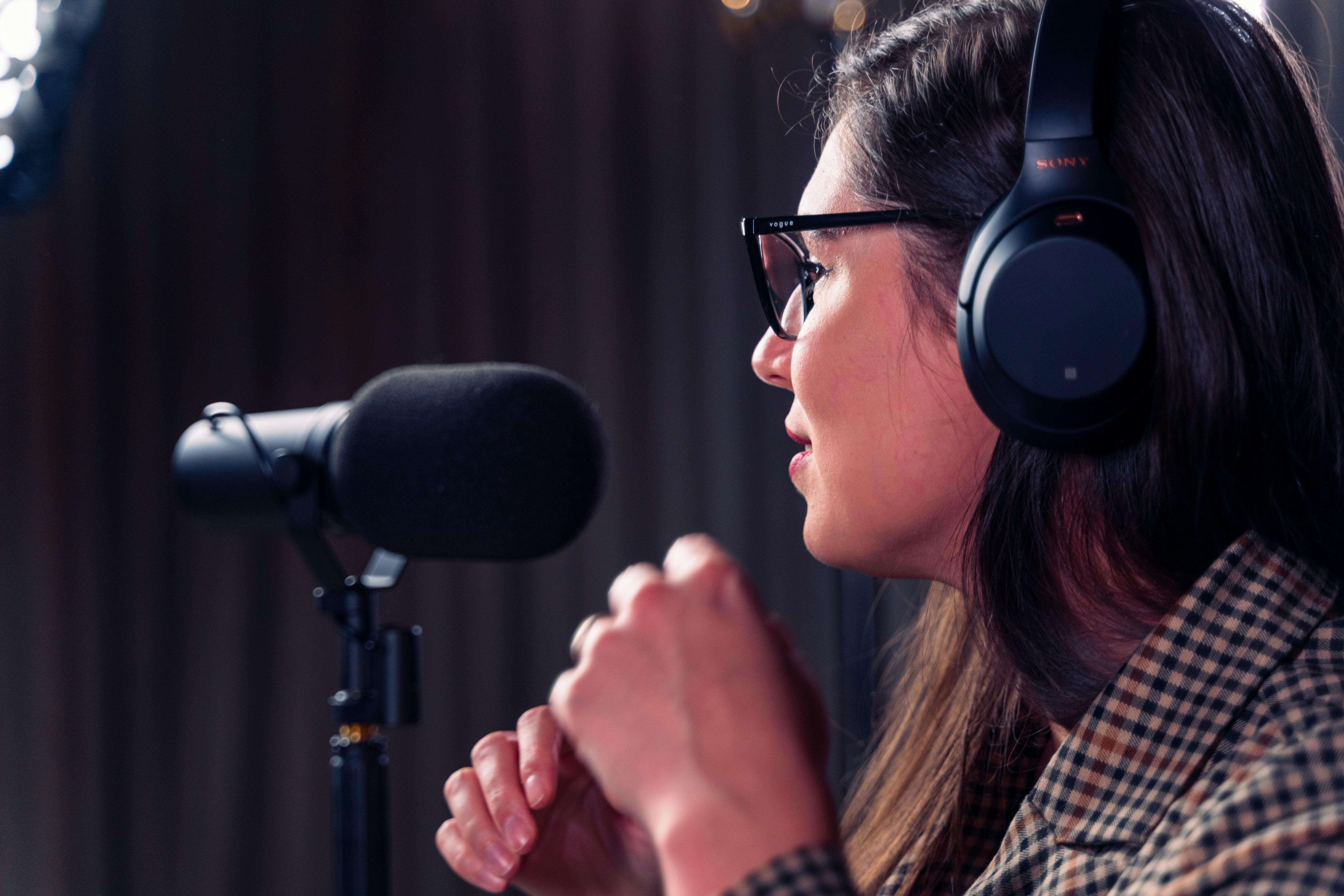 Women wearing headphones speaking into microphone Women wearing headphones speaking into microphone