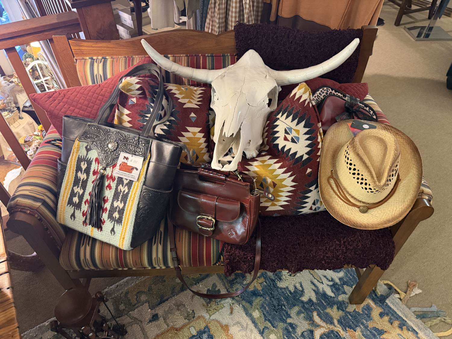 Tooled leather bags, a straw hat and Southwestern pillows at Horse Feathers Mercantile