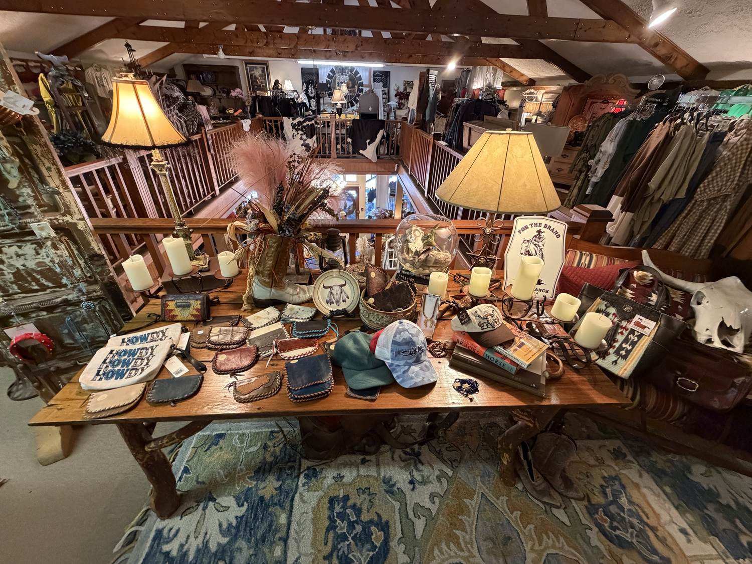 Leather goods, candles and hats on a long table on the upstairs floor at Horse Feathers Mercantile