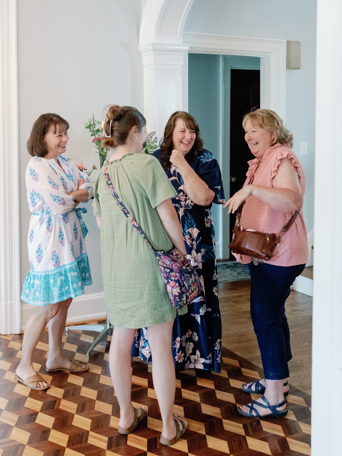 Four guests laughing near an arched doorway during an intimate gathering at Bent Oaks Manor