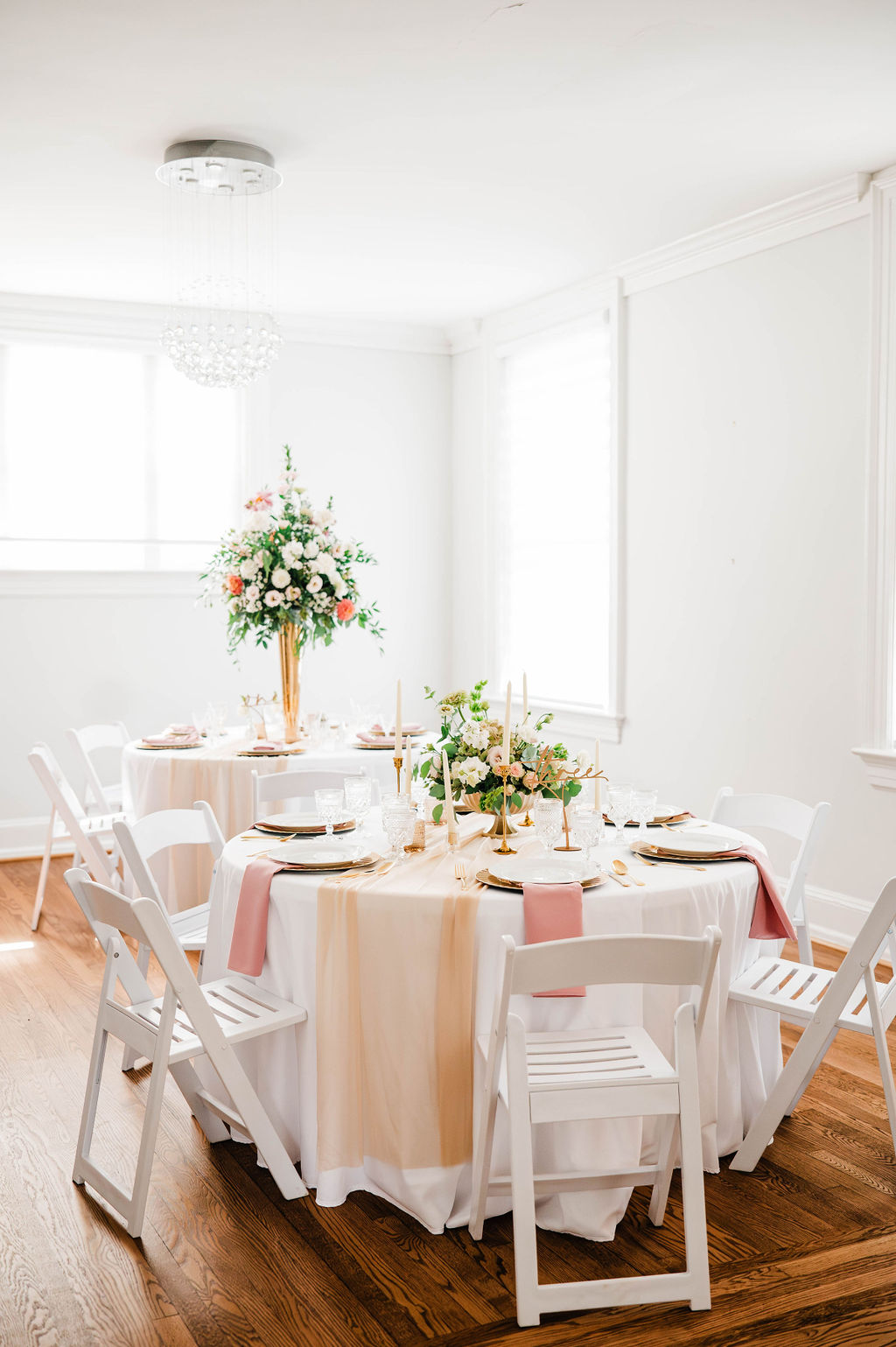 Two round reception tables arranged with chairs in a bright room at Bent Oaks Manor