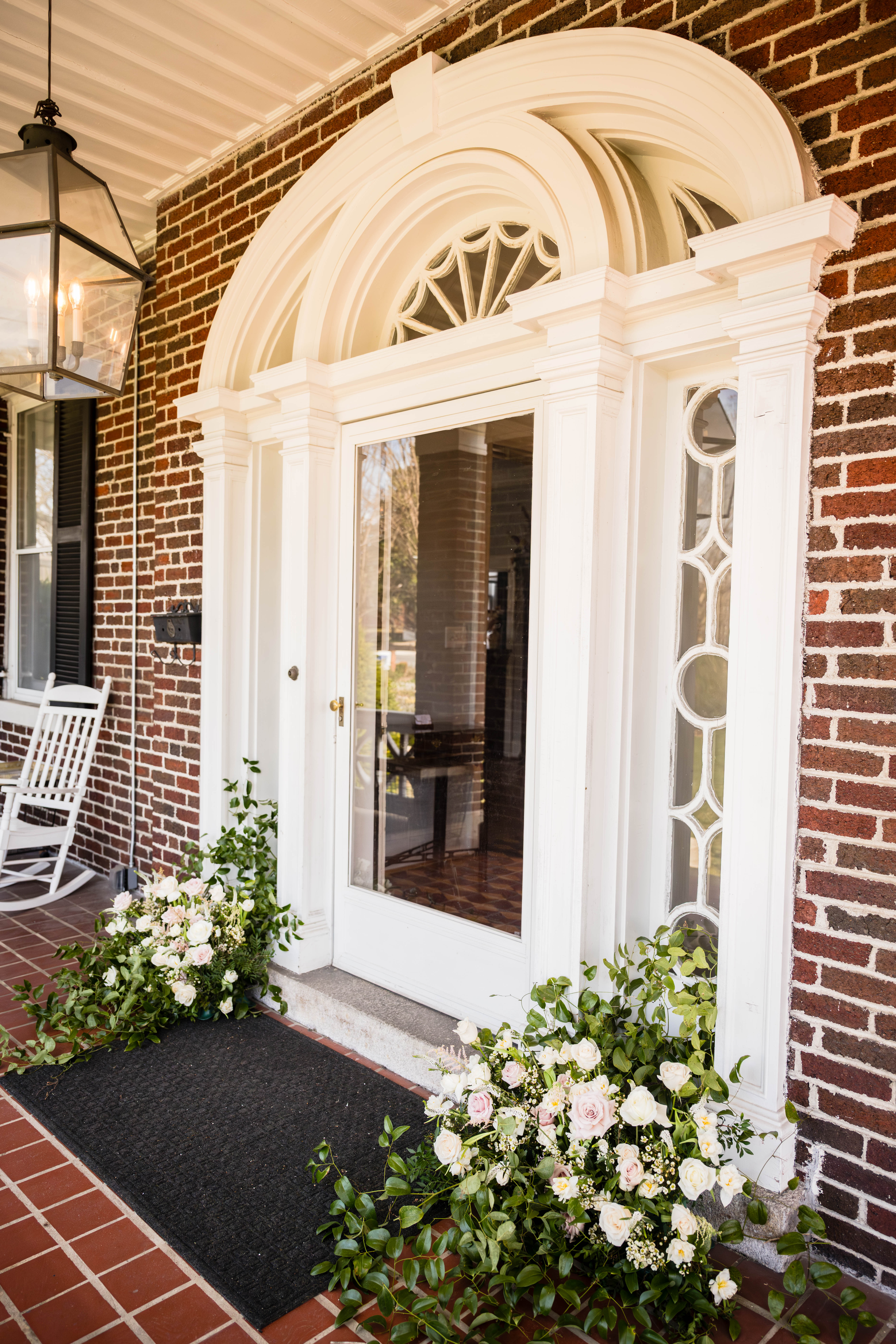 Ornate front entrance at Bent Oaks Manor framed by greenery and floral arrangements
