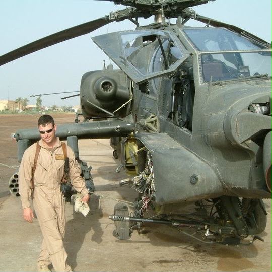 Dennis junto a un helicóptero militar