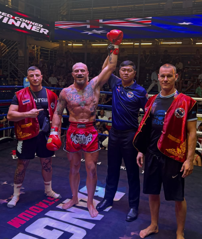 Coach Sloan with his hand raised after winning a muay thai fight in Thailand