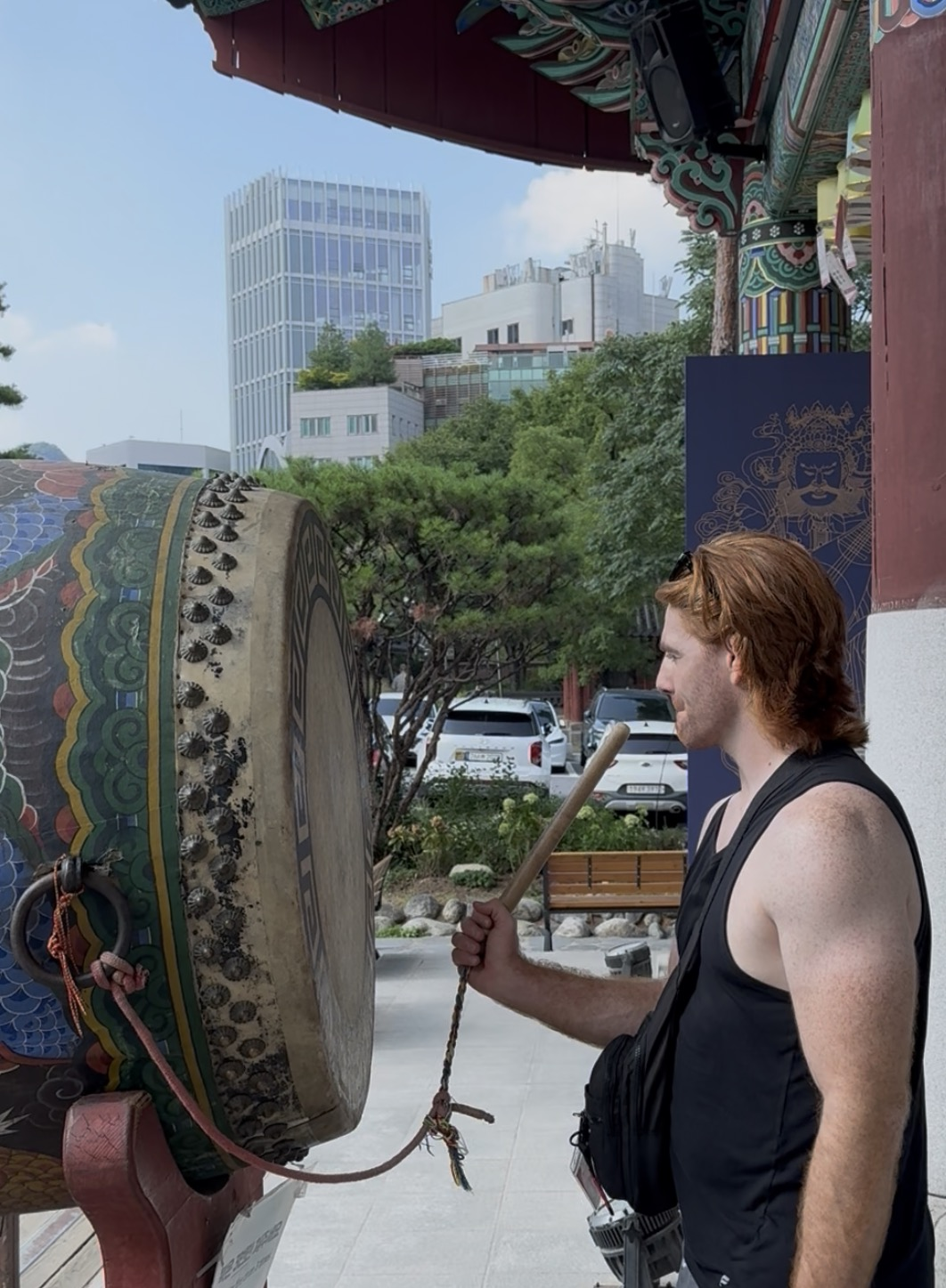Coach Sunshine striking a temple drum in Korea