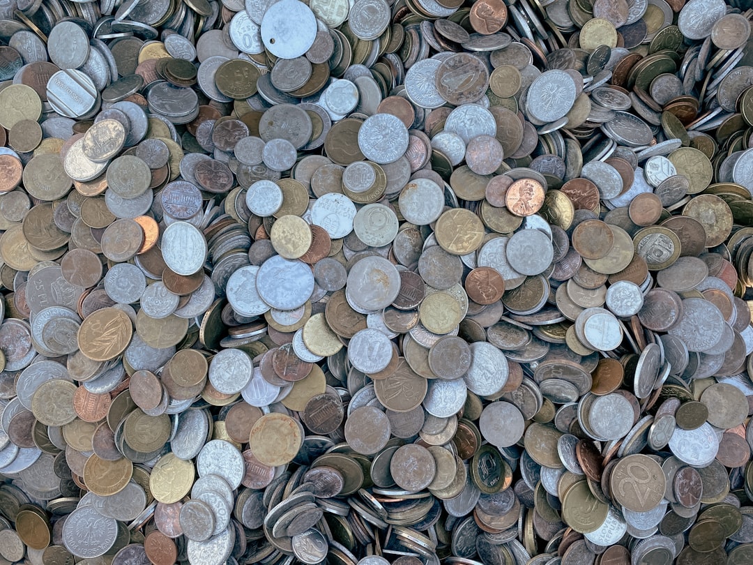 Overhead view of a dense pile of mixed circulated coins filling the frame.