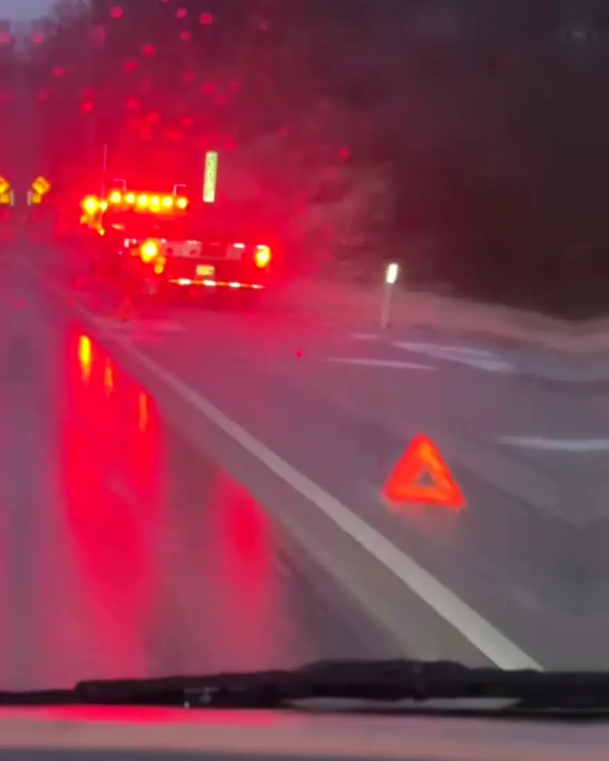 Camión detenido de noche con luces de emergencia en la carretera