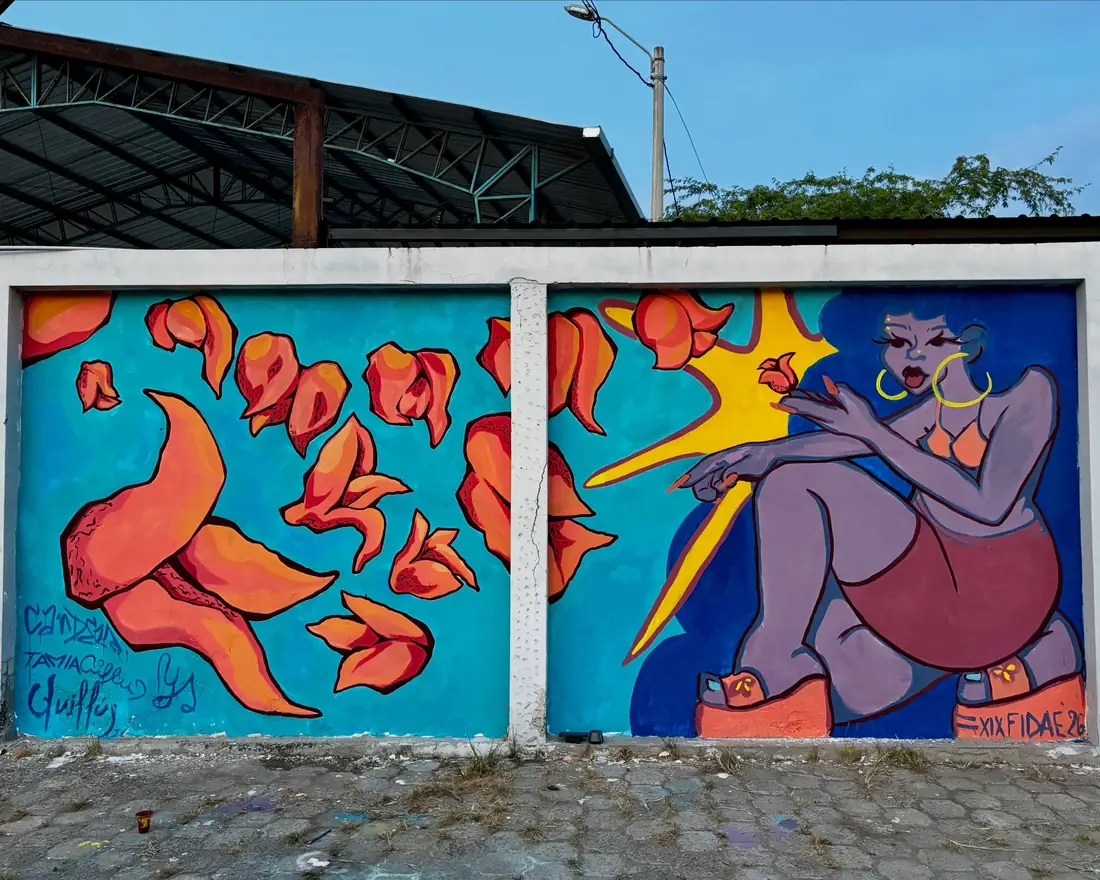 Mural de flores naranjas y una mujer sentada sobre fondo azul en San Jacinto