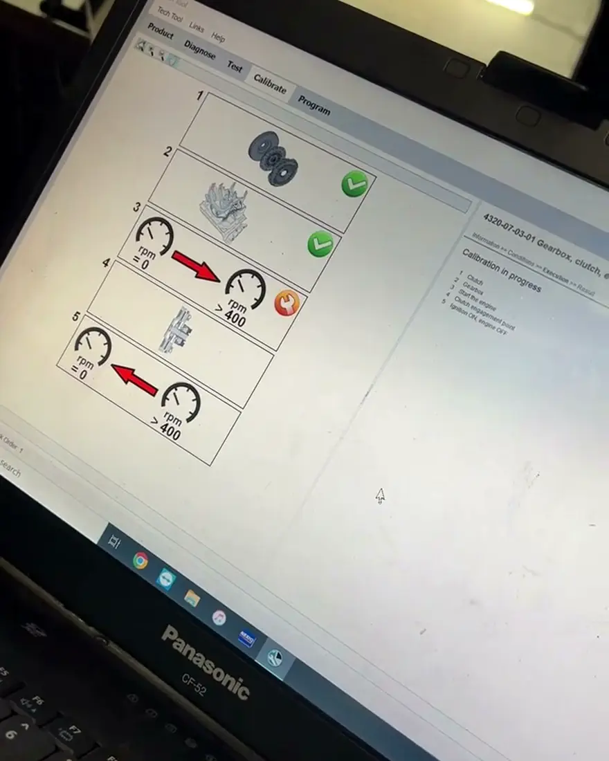 Laptop de diagnóstico conectada a un camión con la prueba de motor en pantalla