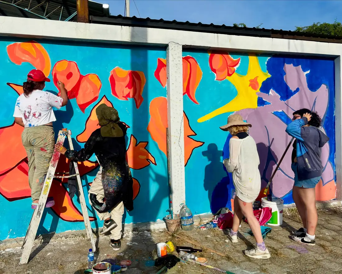 Grupo de artistas pintando un mural colorido en la calle