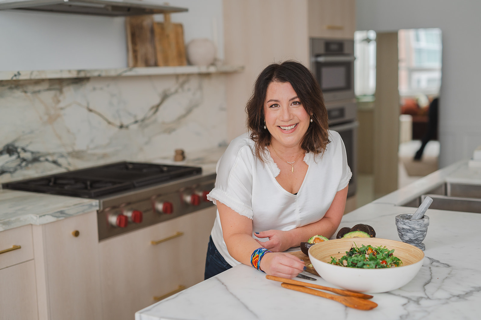 Dr. Laura Brass preparing a fresh salad in her kitchen