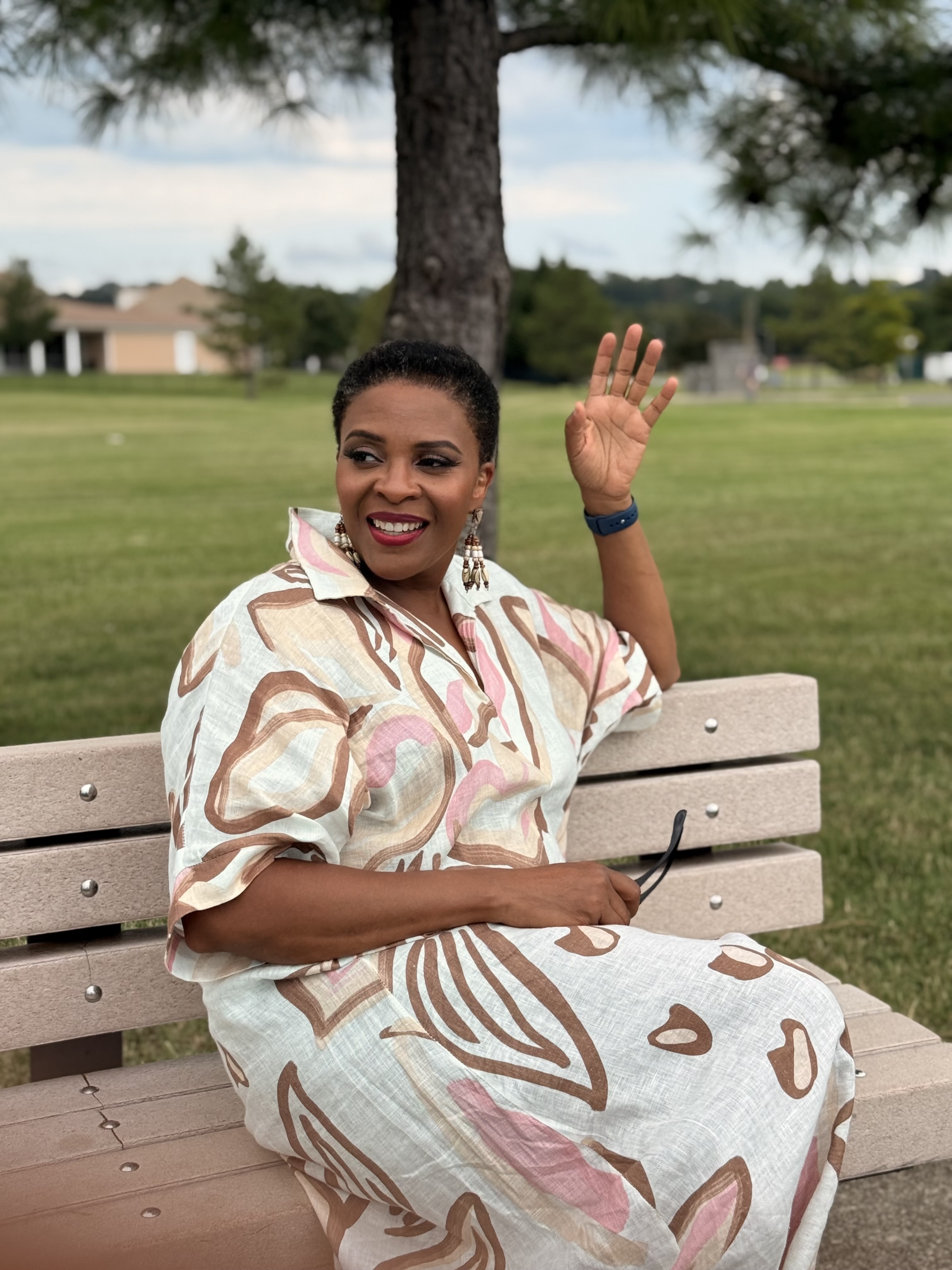 Lori Bell, founder of Ideapop, waving from a park bench