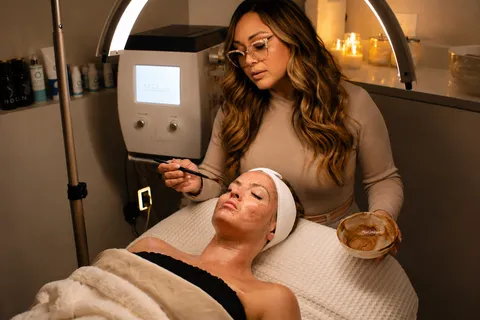 Michelle Marie applying a corrective mask treatment at Michelle Marie Clinical