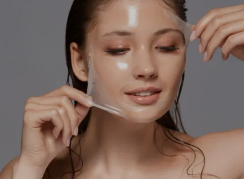 A client lifting a clear peel film away from her cheek