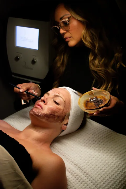 Michelle Marie applying a customized corrective mask during a facial treatment