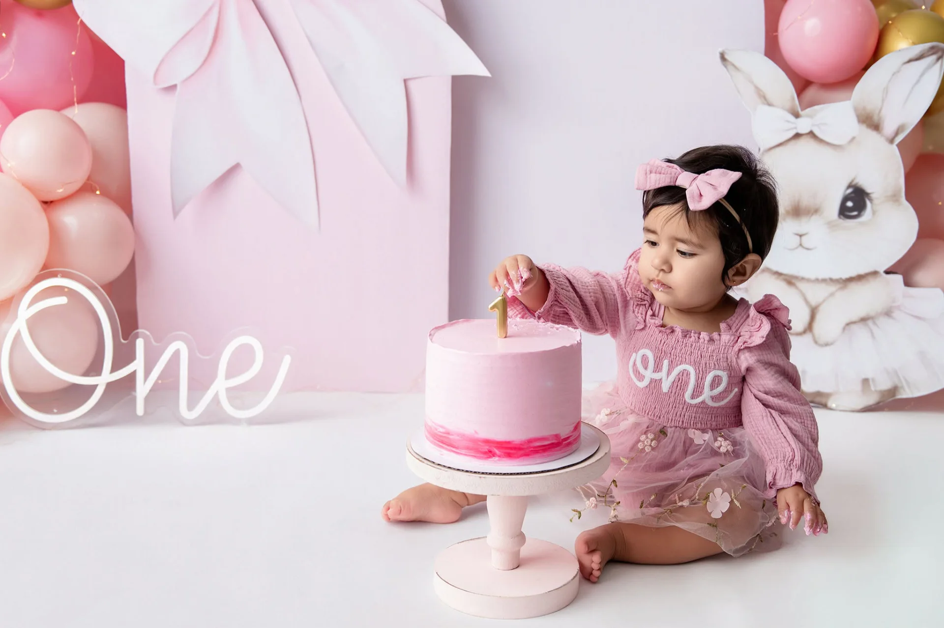 Niña celebrando su cumpleaños con un pastel durante una sesión de fotografía