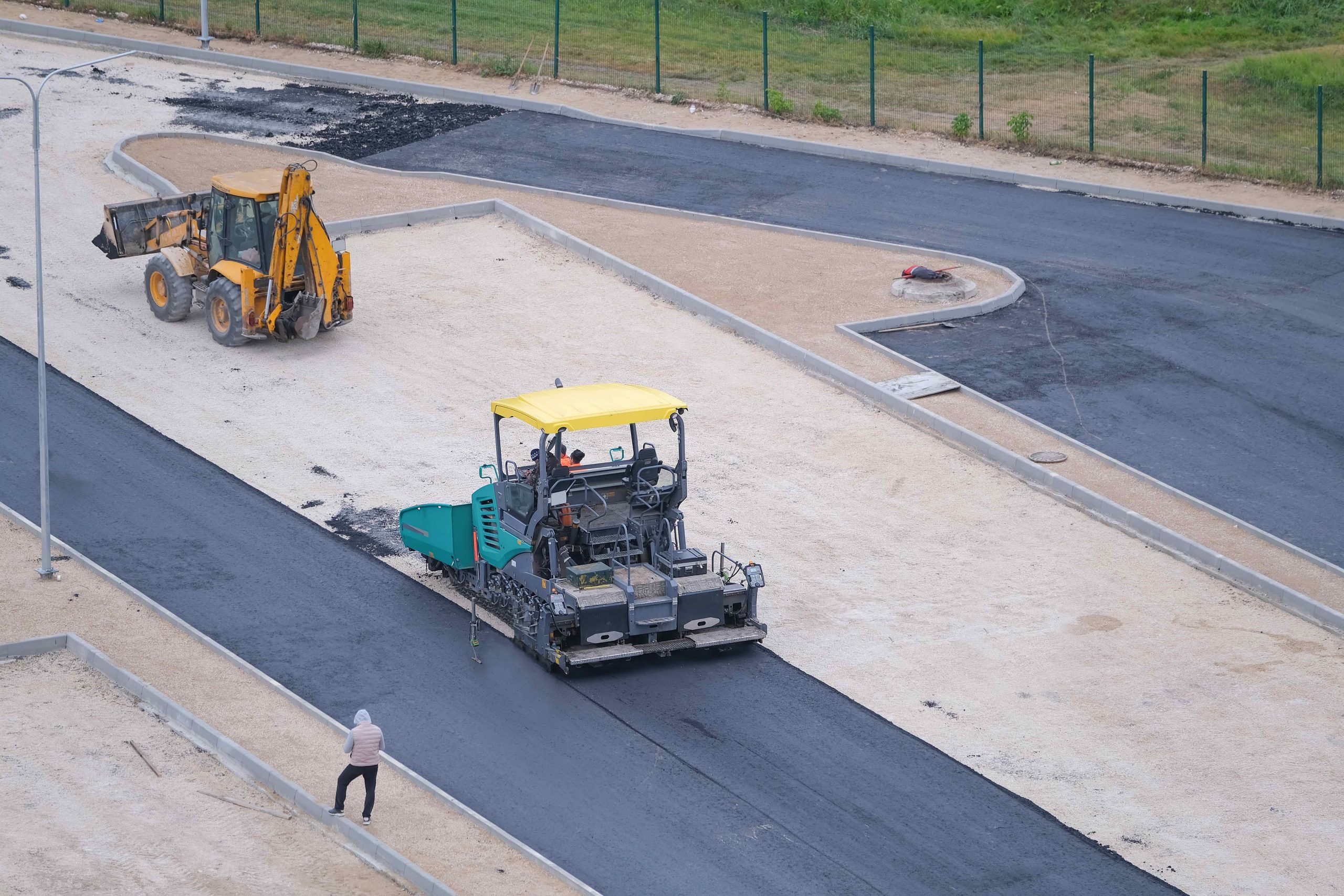 Asphalt paving machine installing new asphalt
