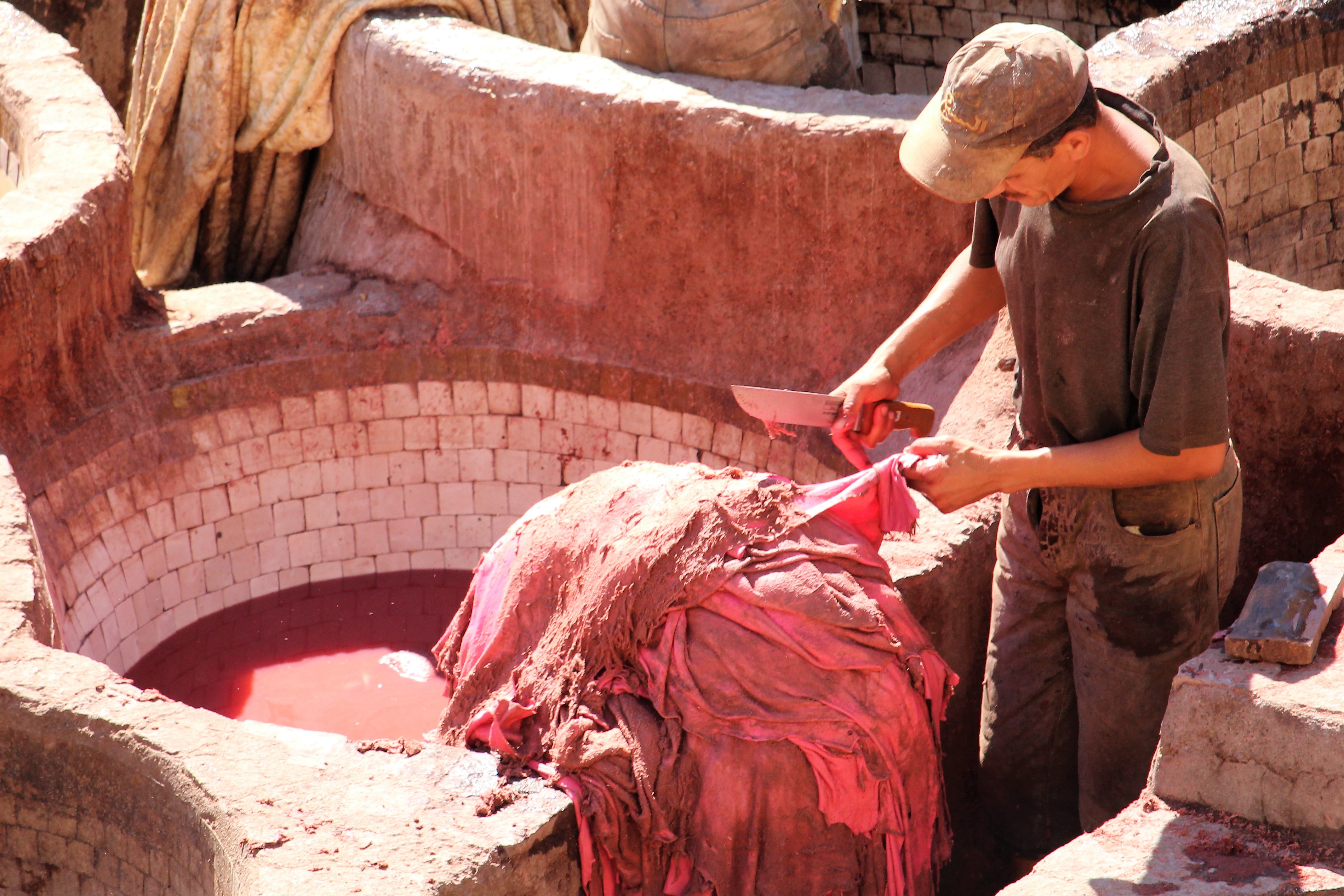 A worker scrapes a hide