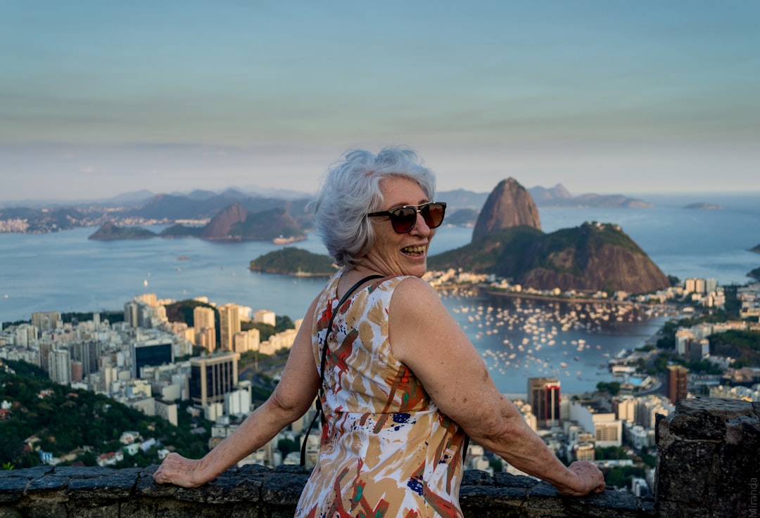 Mature female traveller standing in front of a sea view