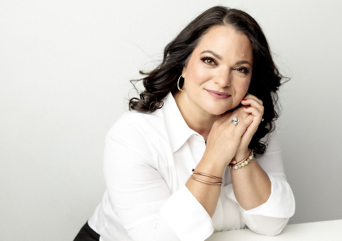 Woman on White background with white shirt, hands by face, warm smile Austin Headshot Photographer - Headshot Trends 2026