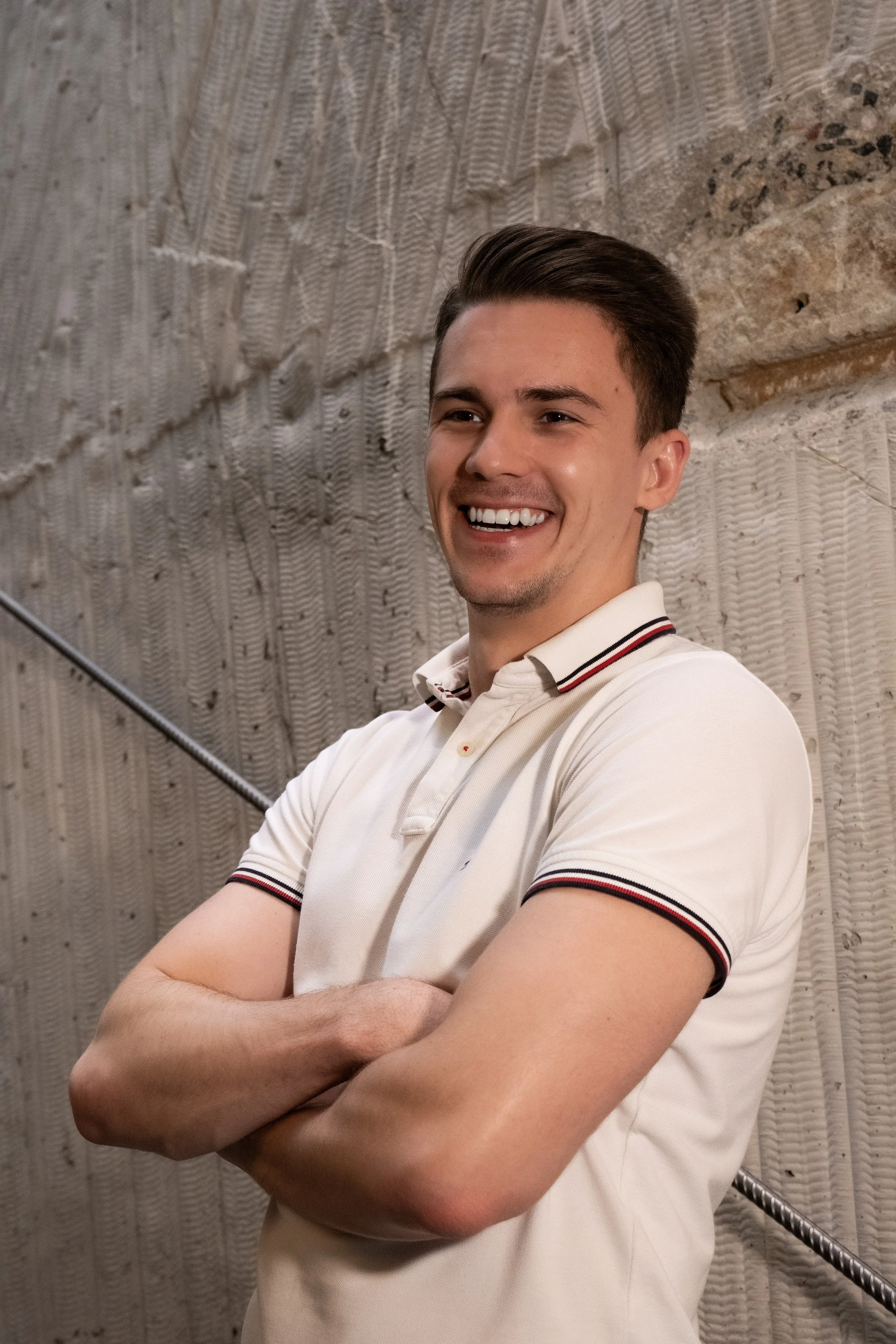 Filip Kollert smiling with arms crossed