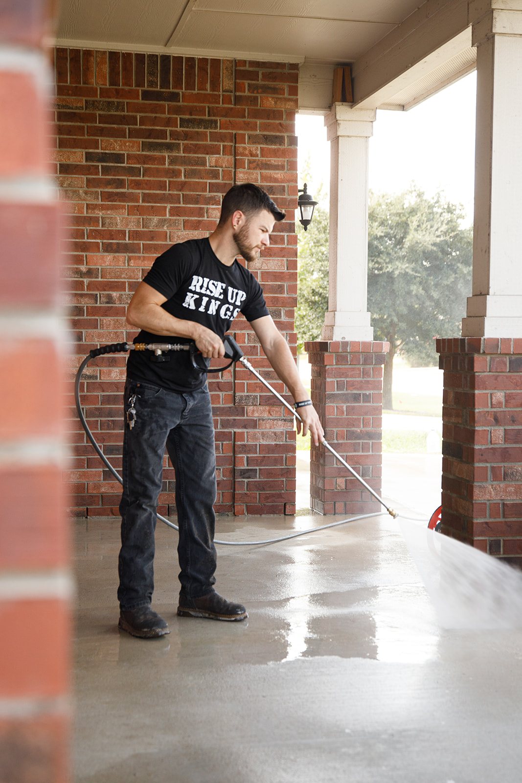 Charles Baker pressure washing a Bell County porch