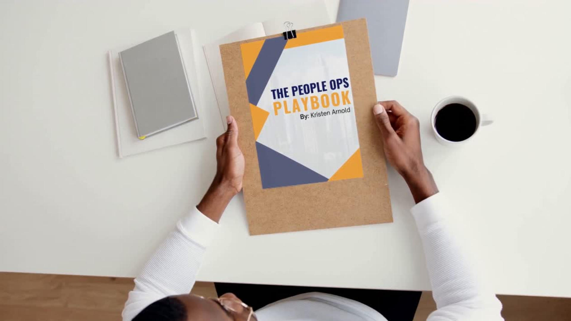 Person holding a printed copy of The People Ops Playbook by Kristen Arnold, a guide for founders to build team ownership, leadership systems, and operational clarity.