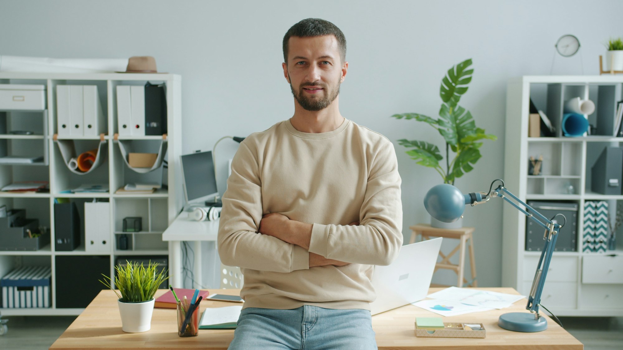 A business owner standing with arms crossed in his office
