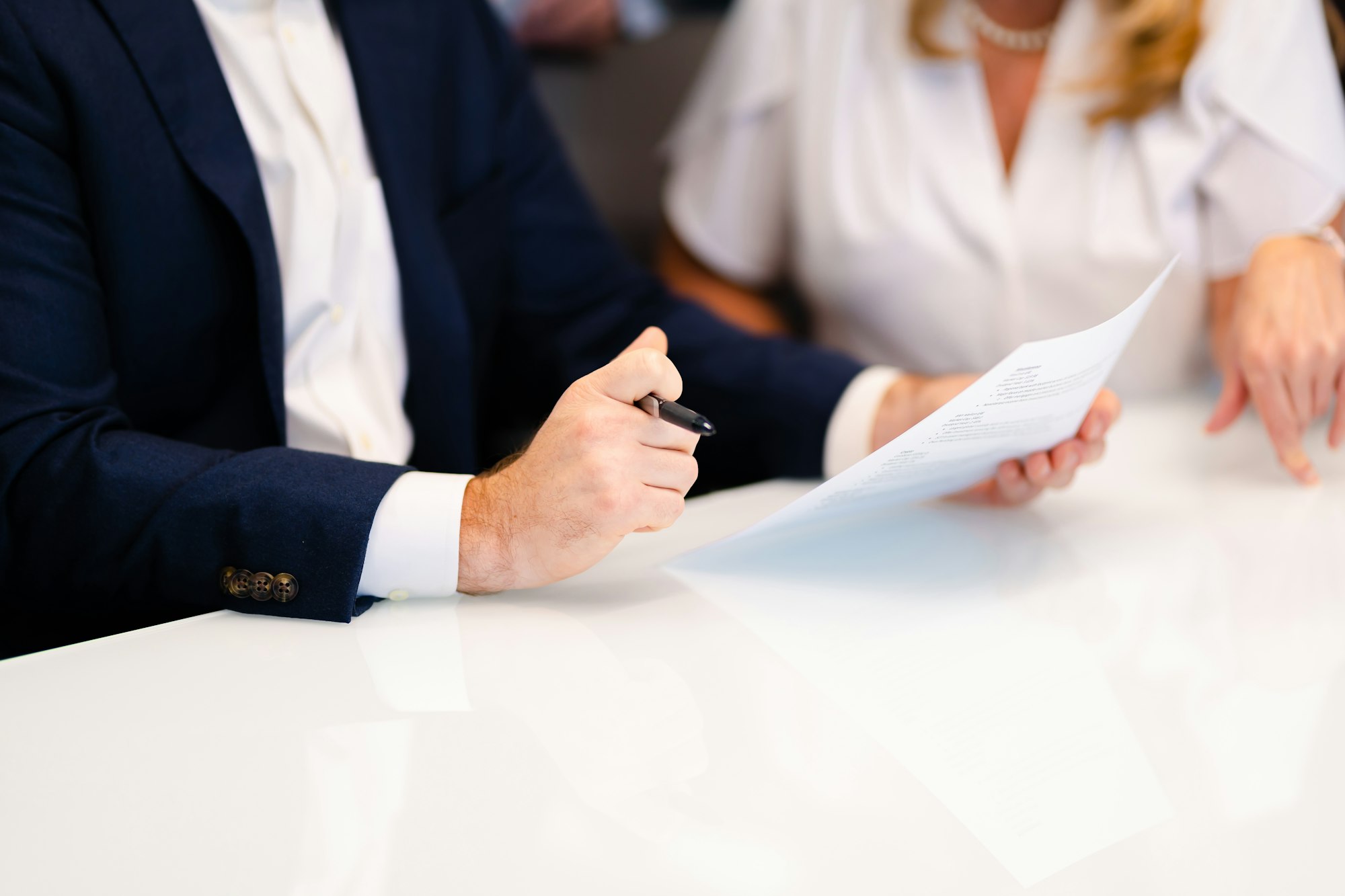 An advisor reviewing documents with a client at a white table