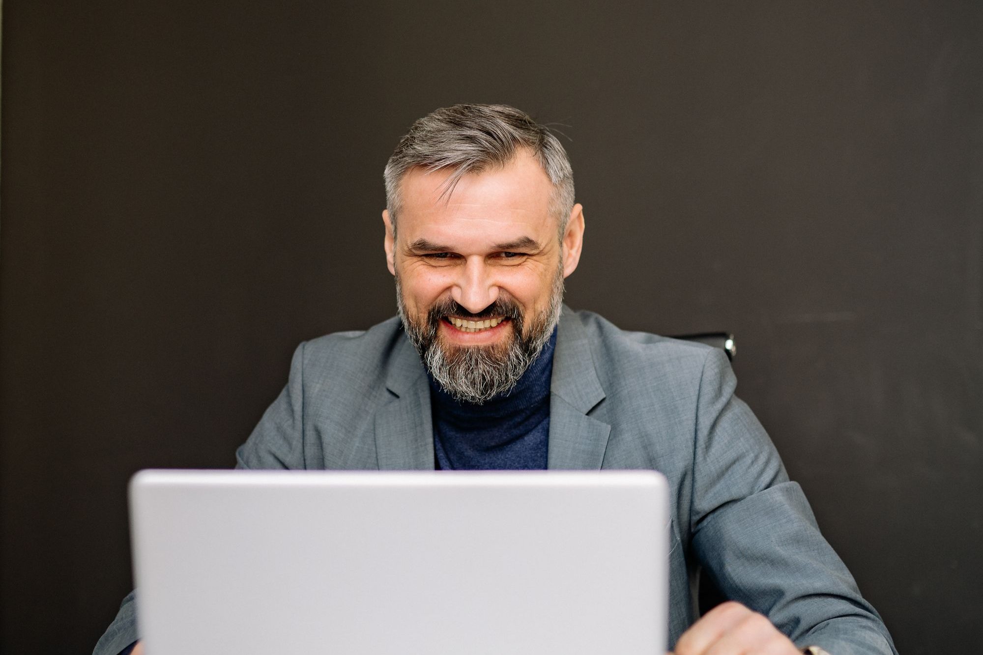 A business owner answering questions on his laptop