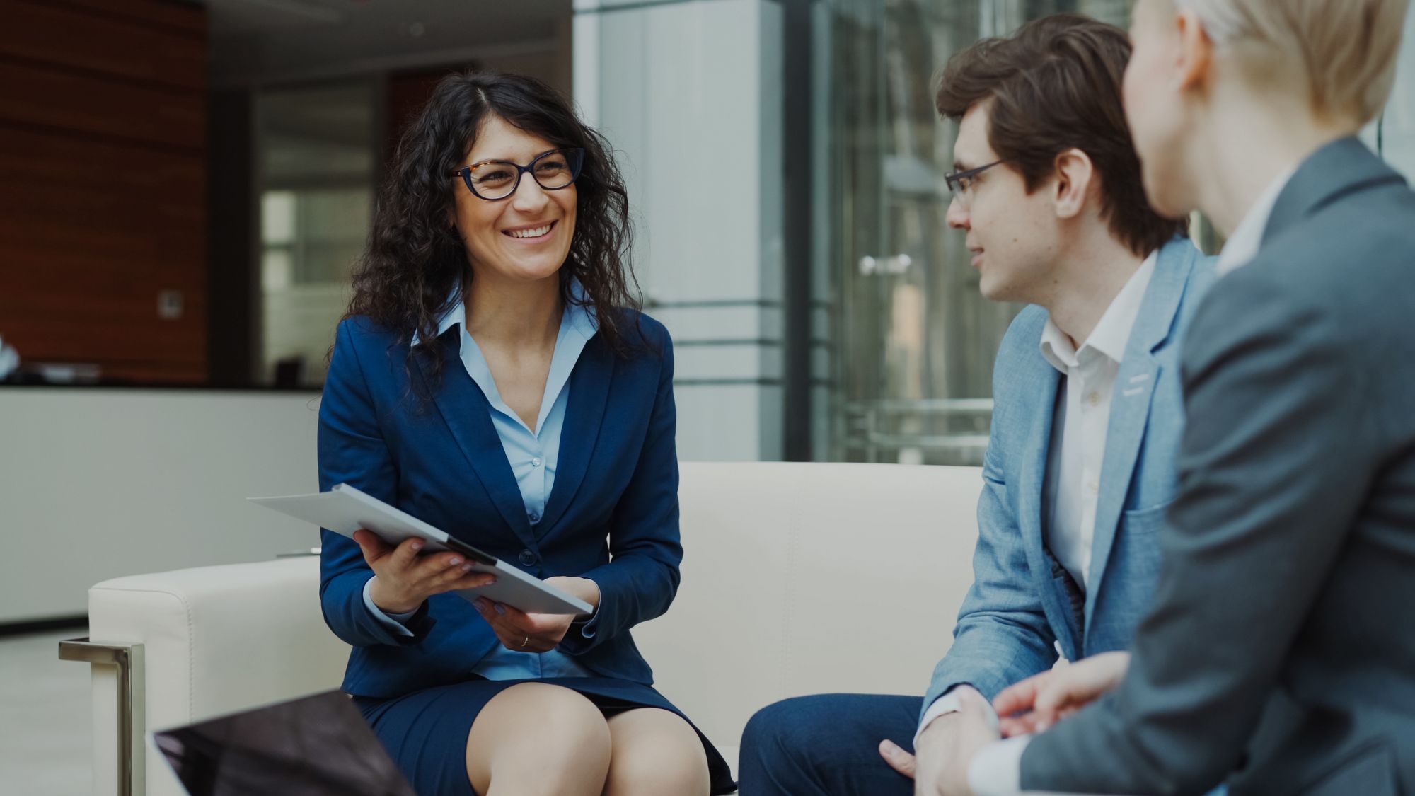An exit advisor reviewing a plan with two business owners in a bright office