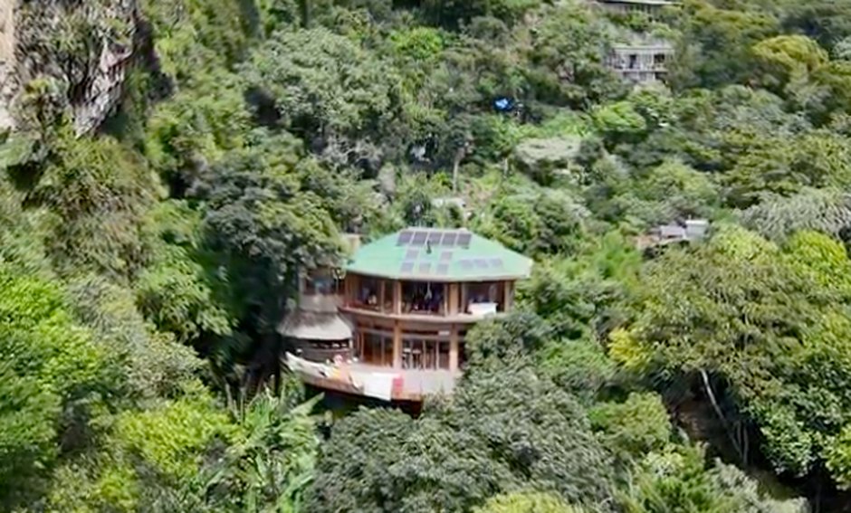 Solar-roofed building set into the cliffside above the valley