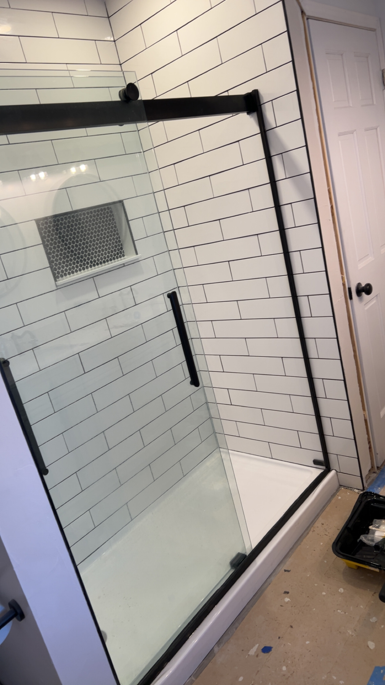 Subway tile shower with a black frame
