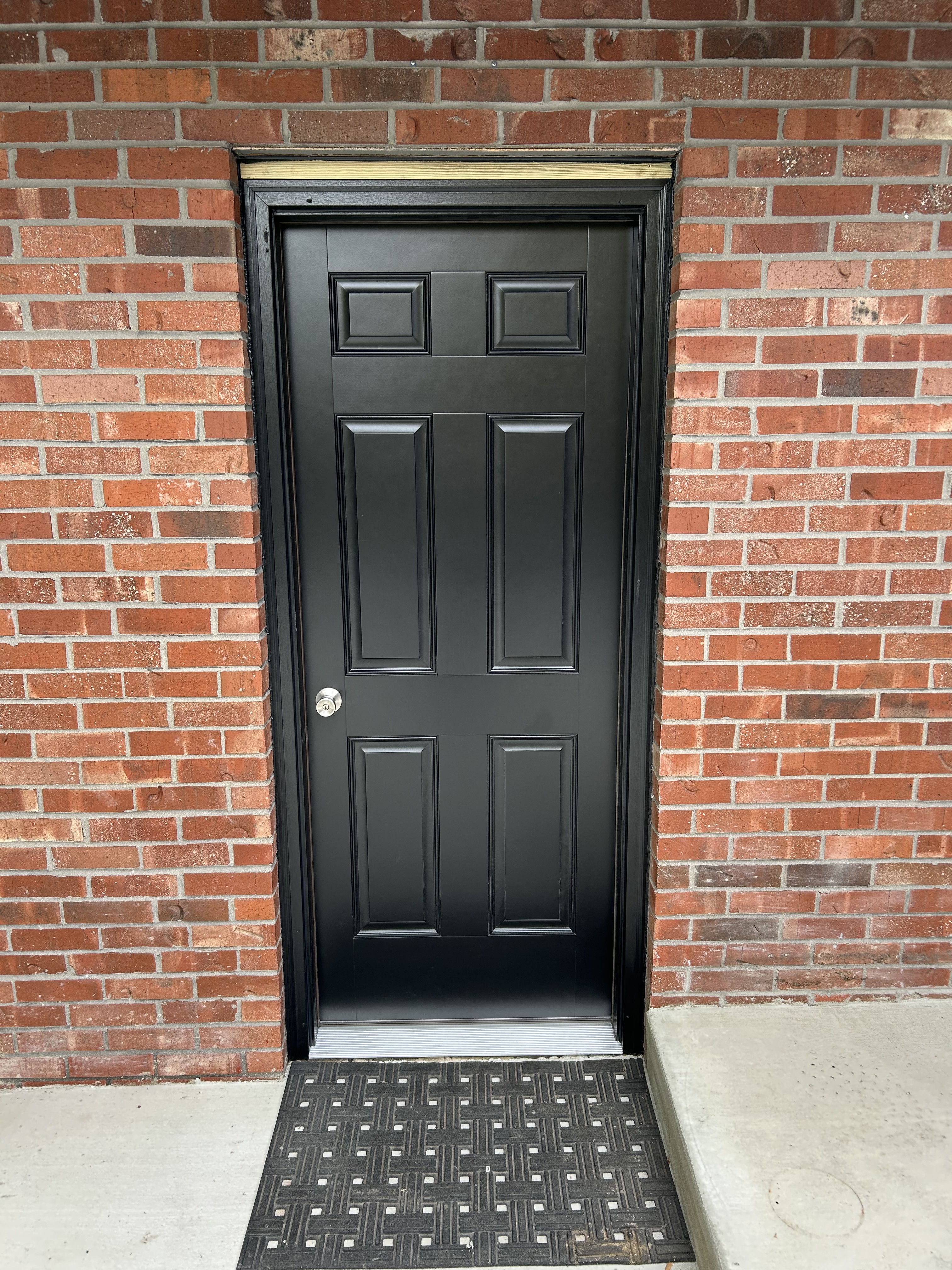Black front door on a brick exterior