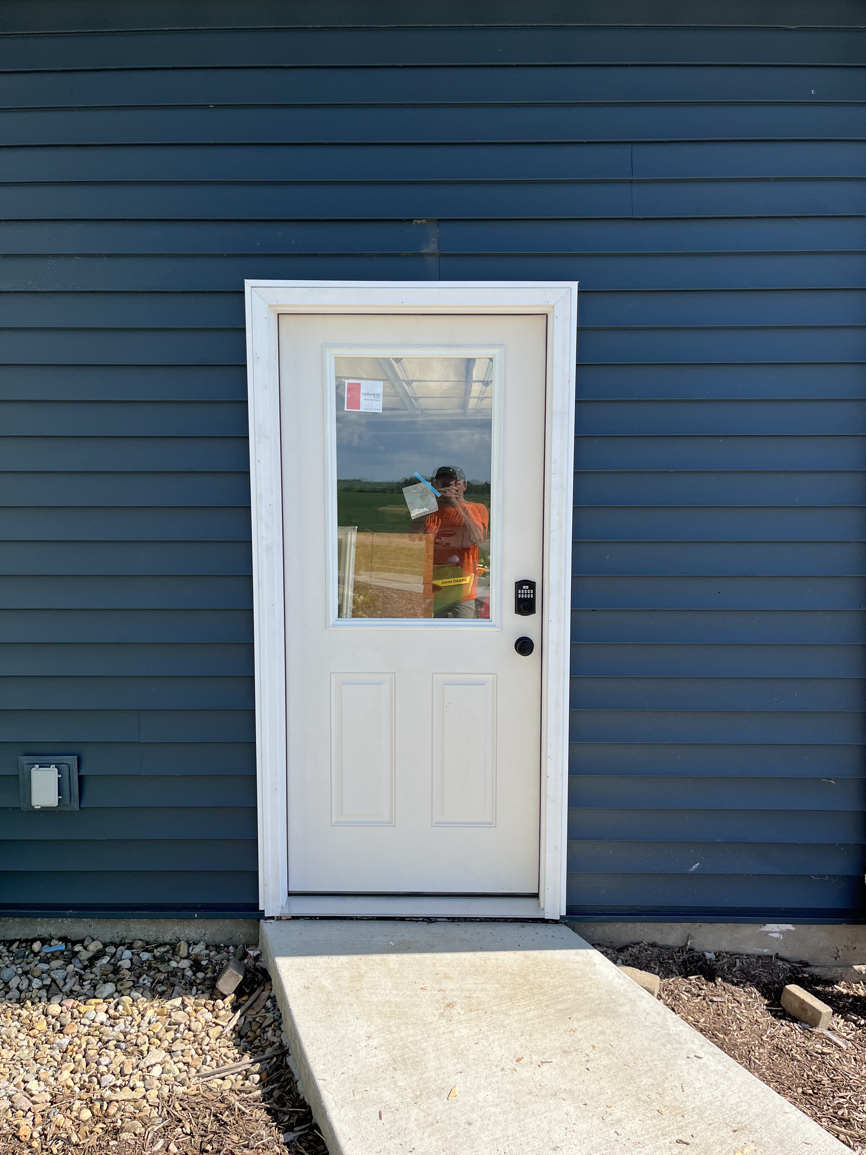 White exterior door with blue siding