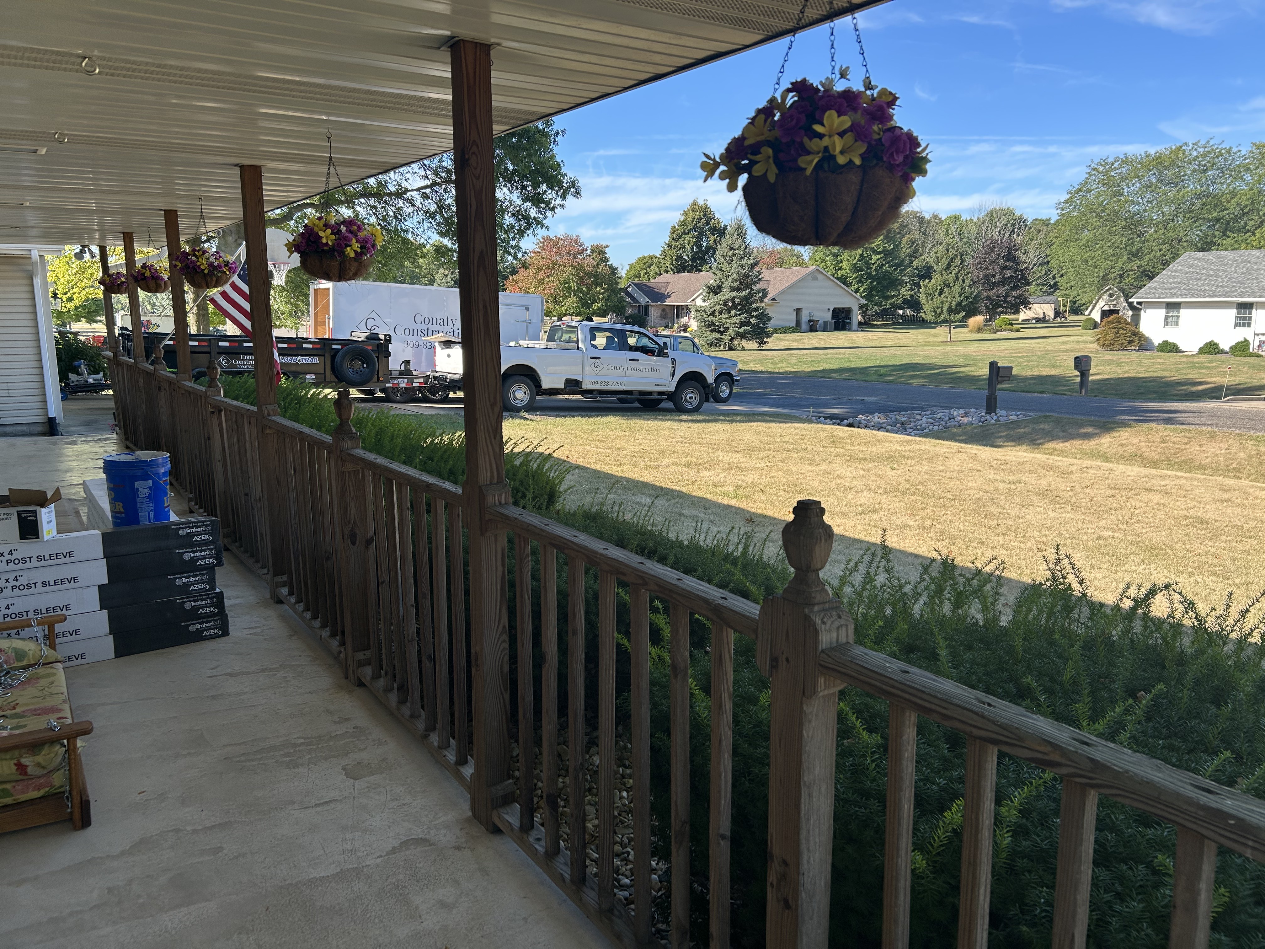 Covered porch with worn wood railing before rebuilding