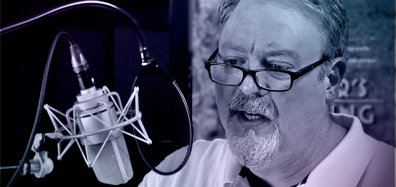 Professional voice-over artist Jason Fredregill recording at the microphone in his Des Moines studio