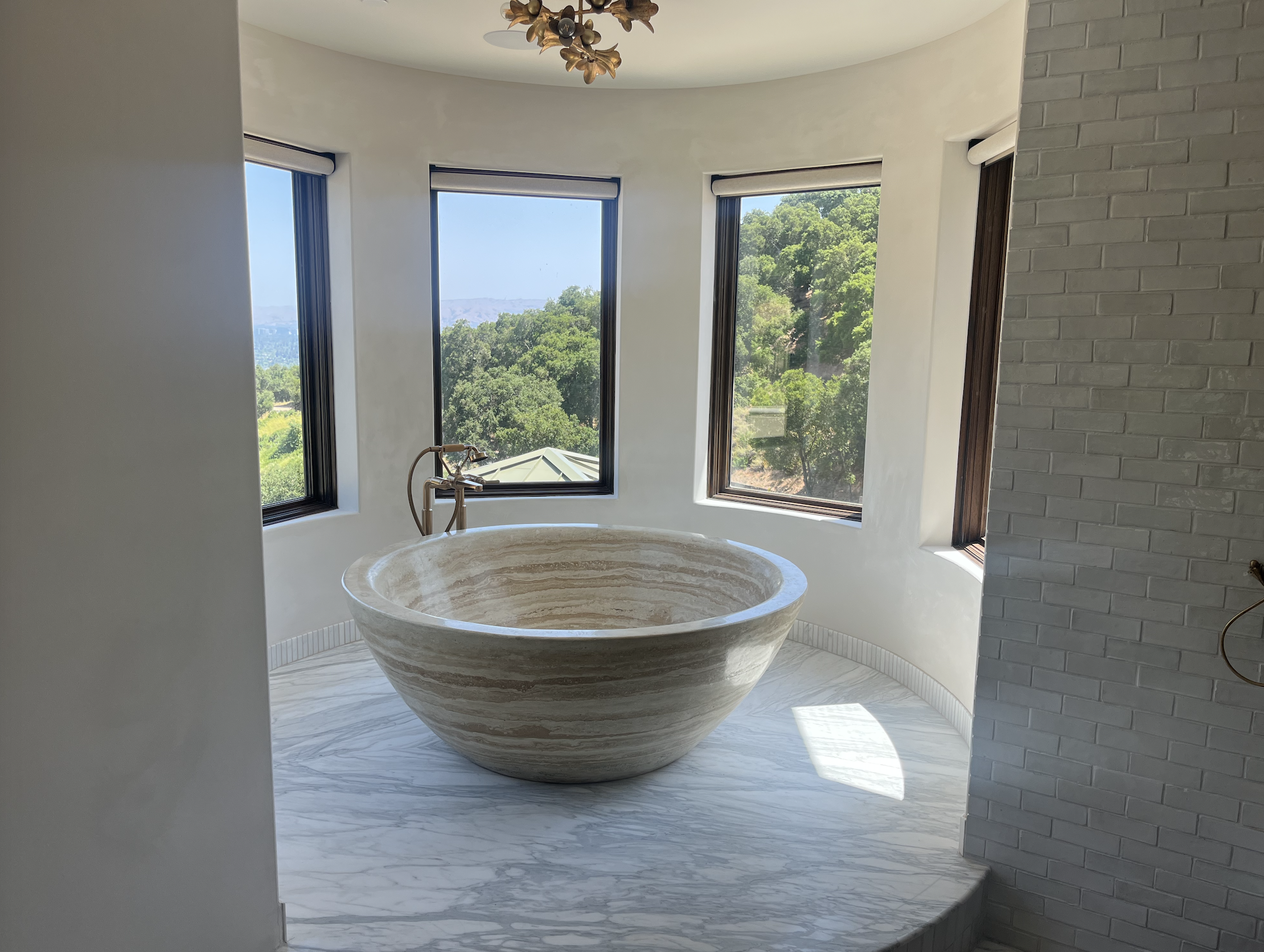 Travertine soaking tub with hillside view