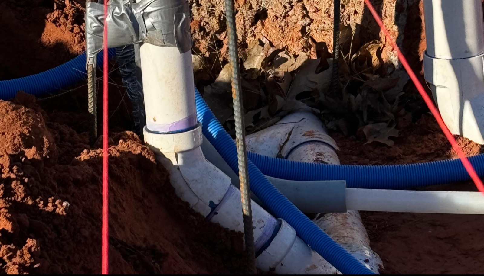 Active utilities job, white pipe and blue conduit in a trench